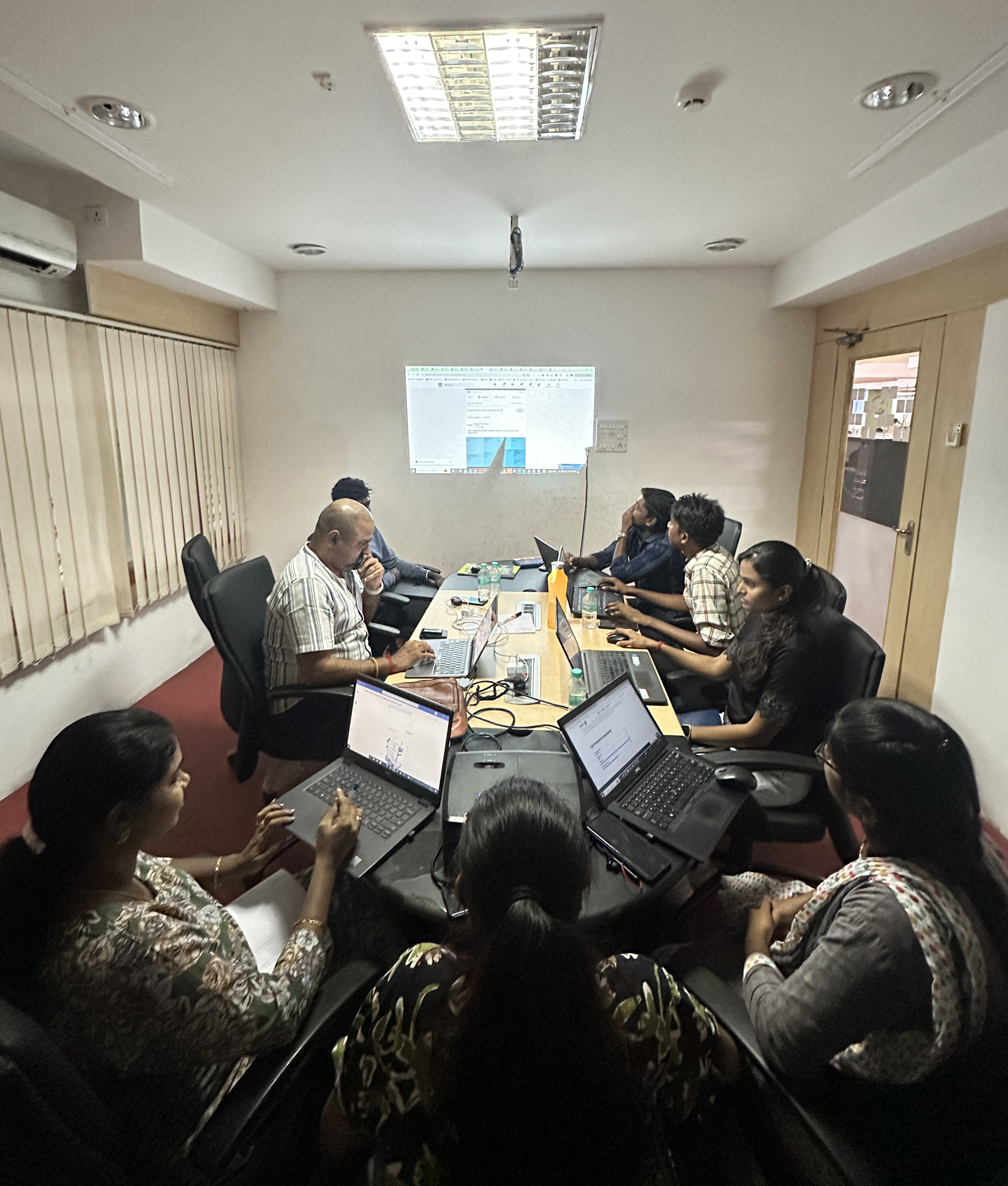 The Maxbyte team in a working session, laptops open around a table with the audit on screen